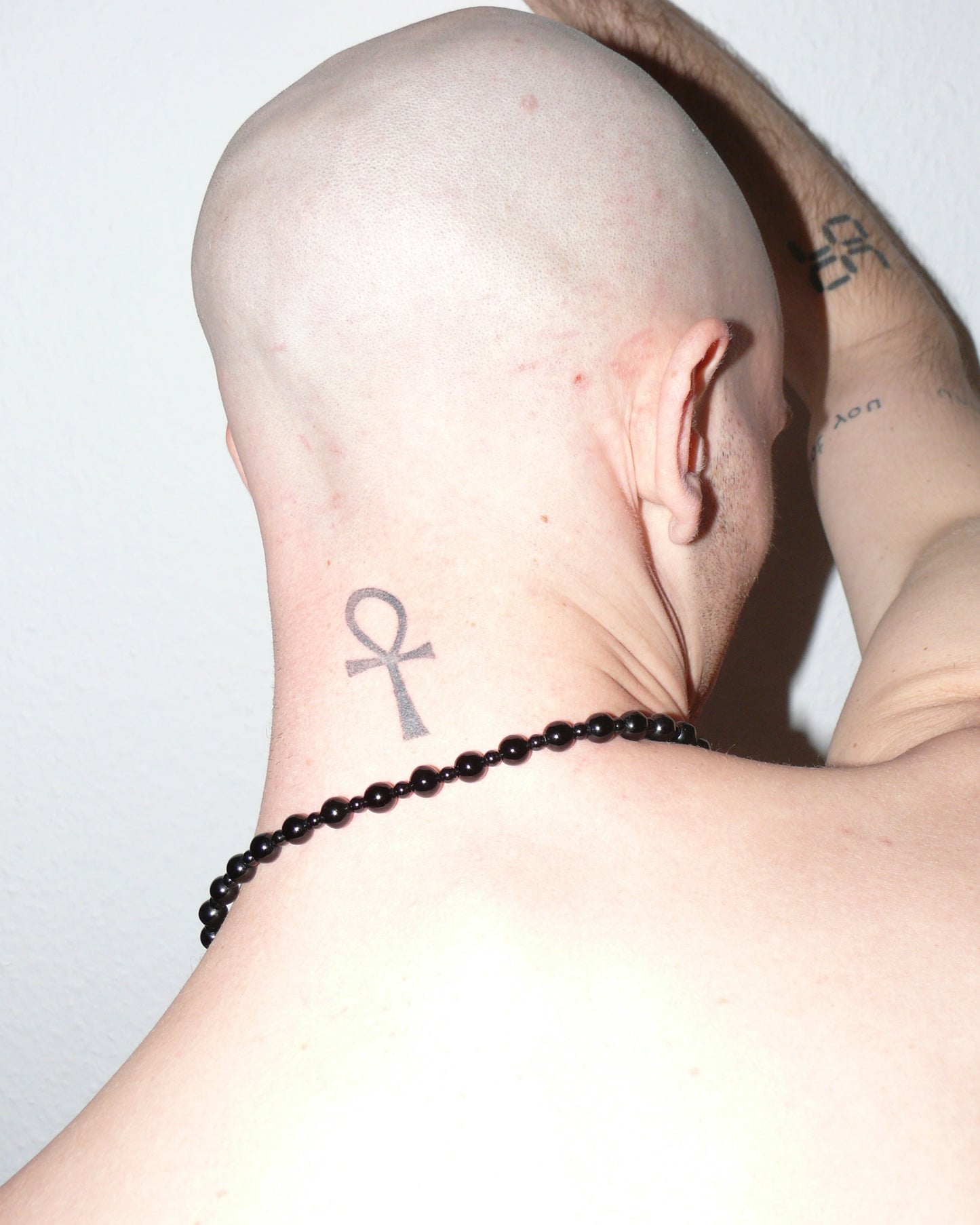 Black agate beads necklace with piercing closure close-up on model back neck