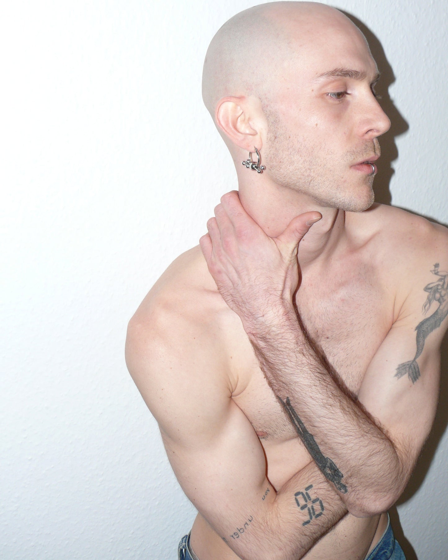 Multiple steel barbells decoration hoop earrings side portrait on model with hand on neck