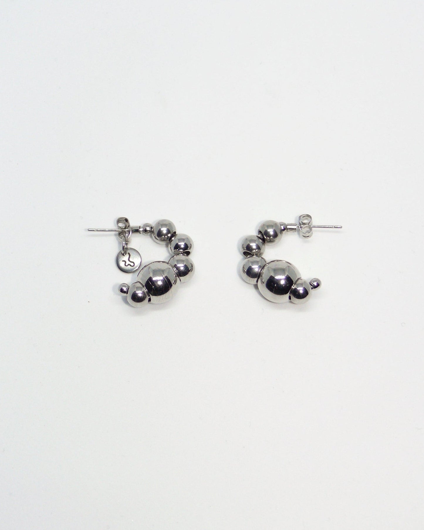 Pair of silver beaded earrings on a light gray background