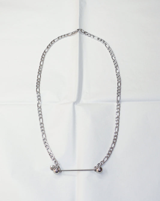 Silver chain necklace with barbell closure on folded paper