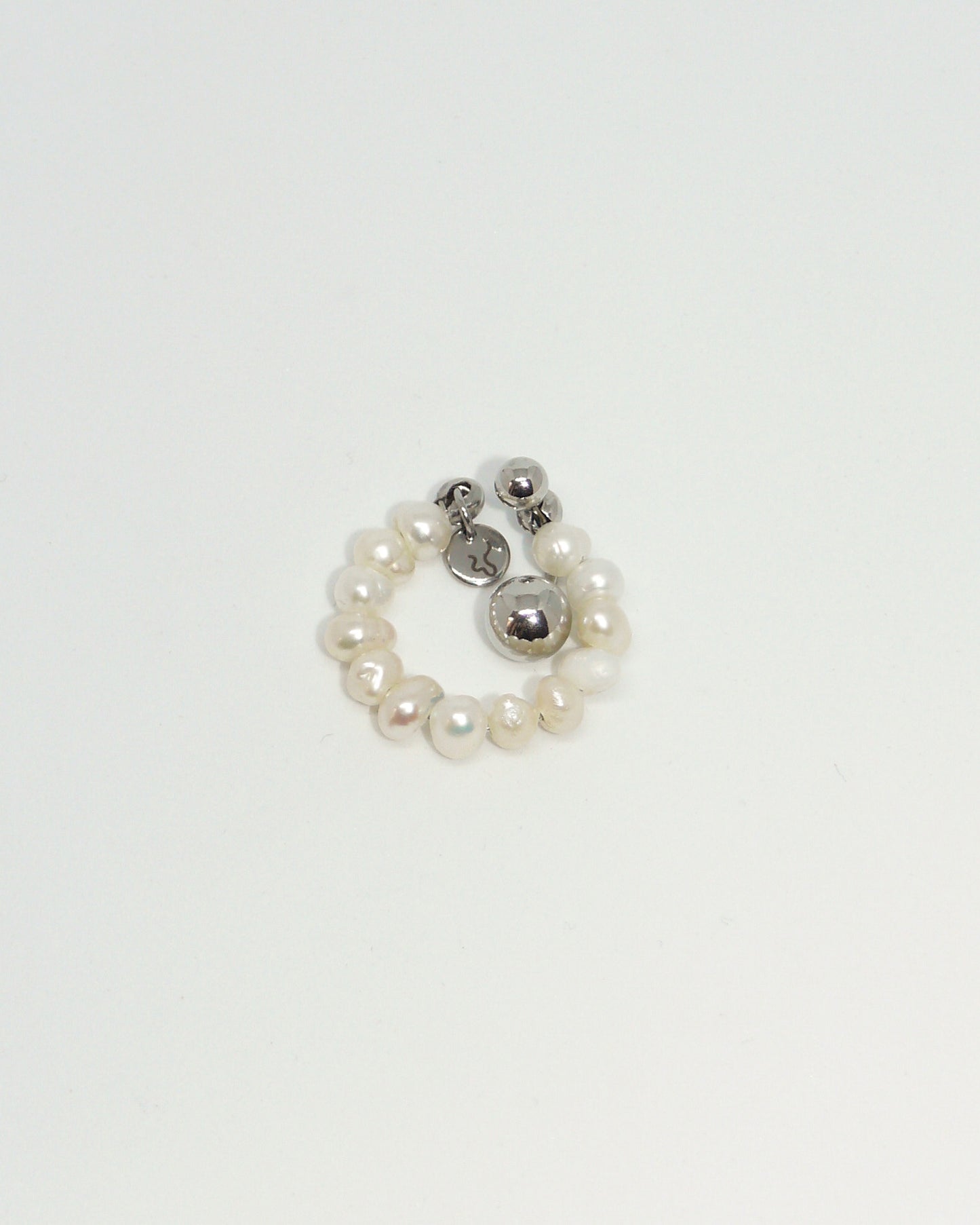 Small ring with pearls and a silver bead on a white background