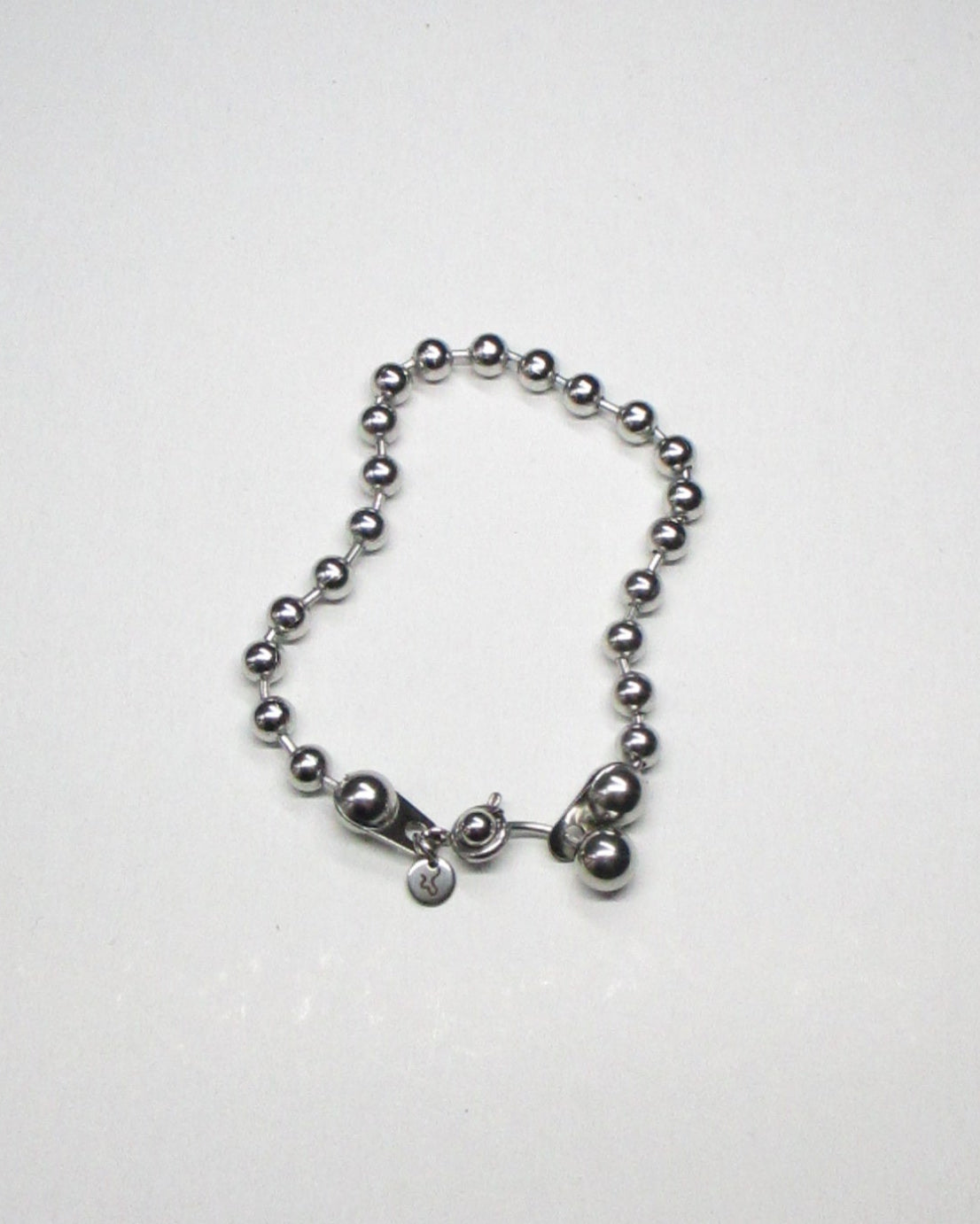 Steel ball chain bracelet with piercing closure still fluid portrait