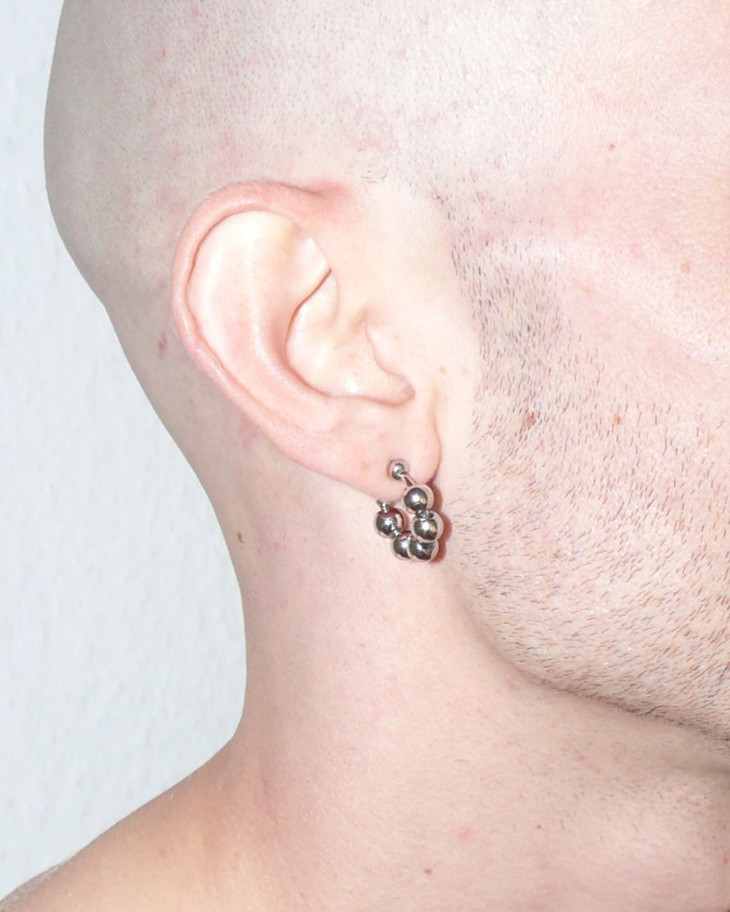 Steel ball chain mini open hoops earrings close up portrait on white model ear