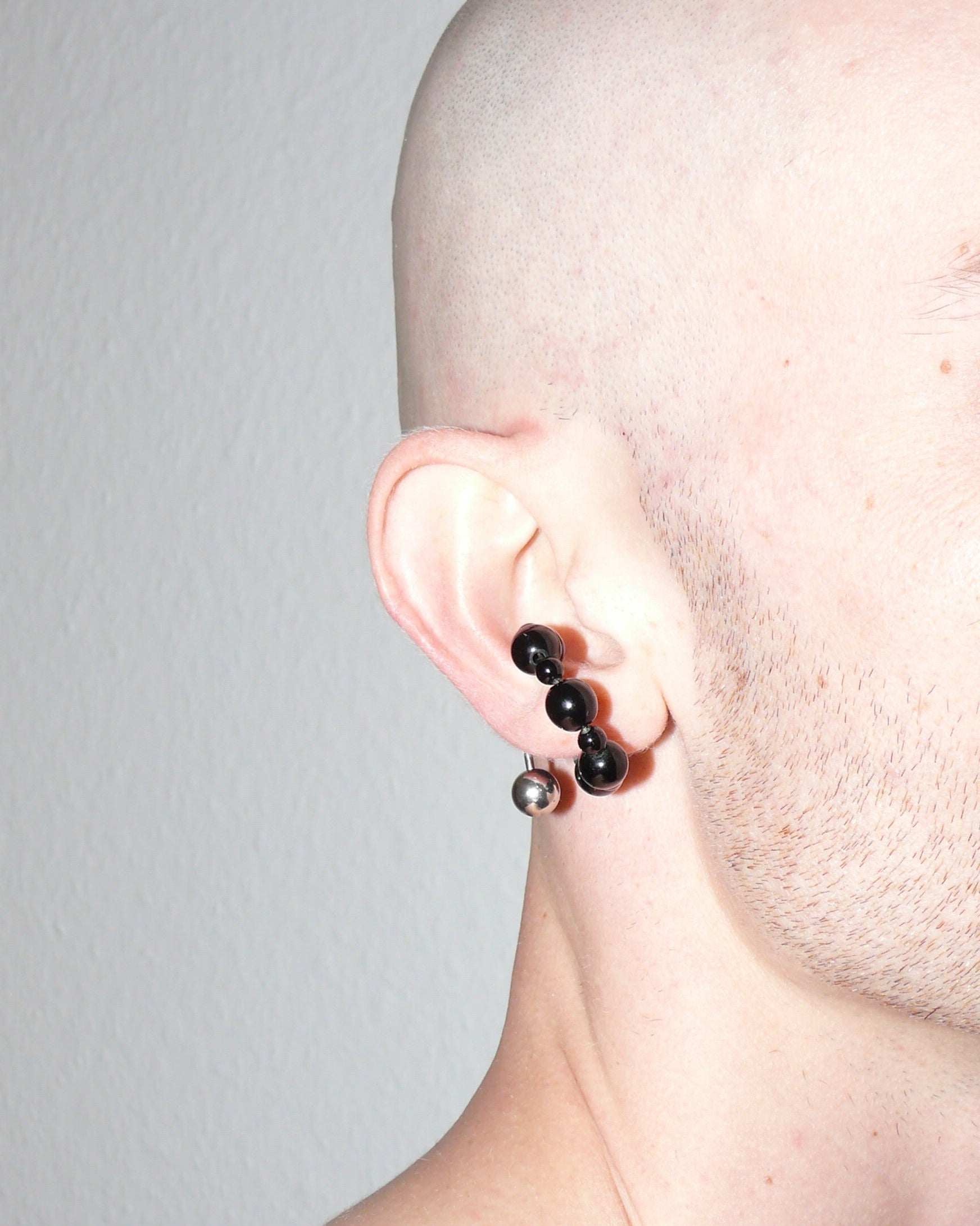 Black agate beads cuff with piercing decoration close-up on model