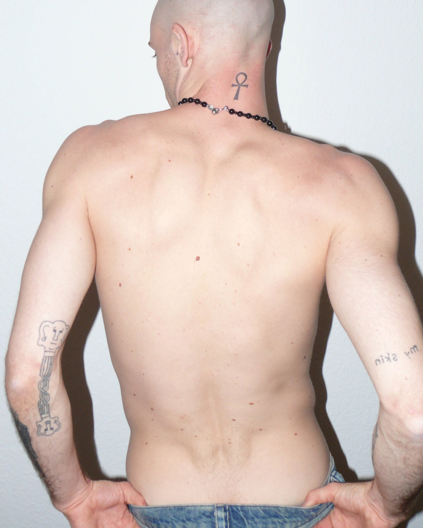 Black agate beads necklace with piercing closure close-up on model back