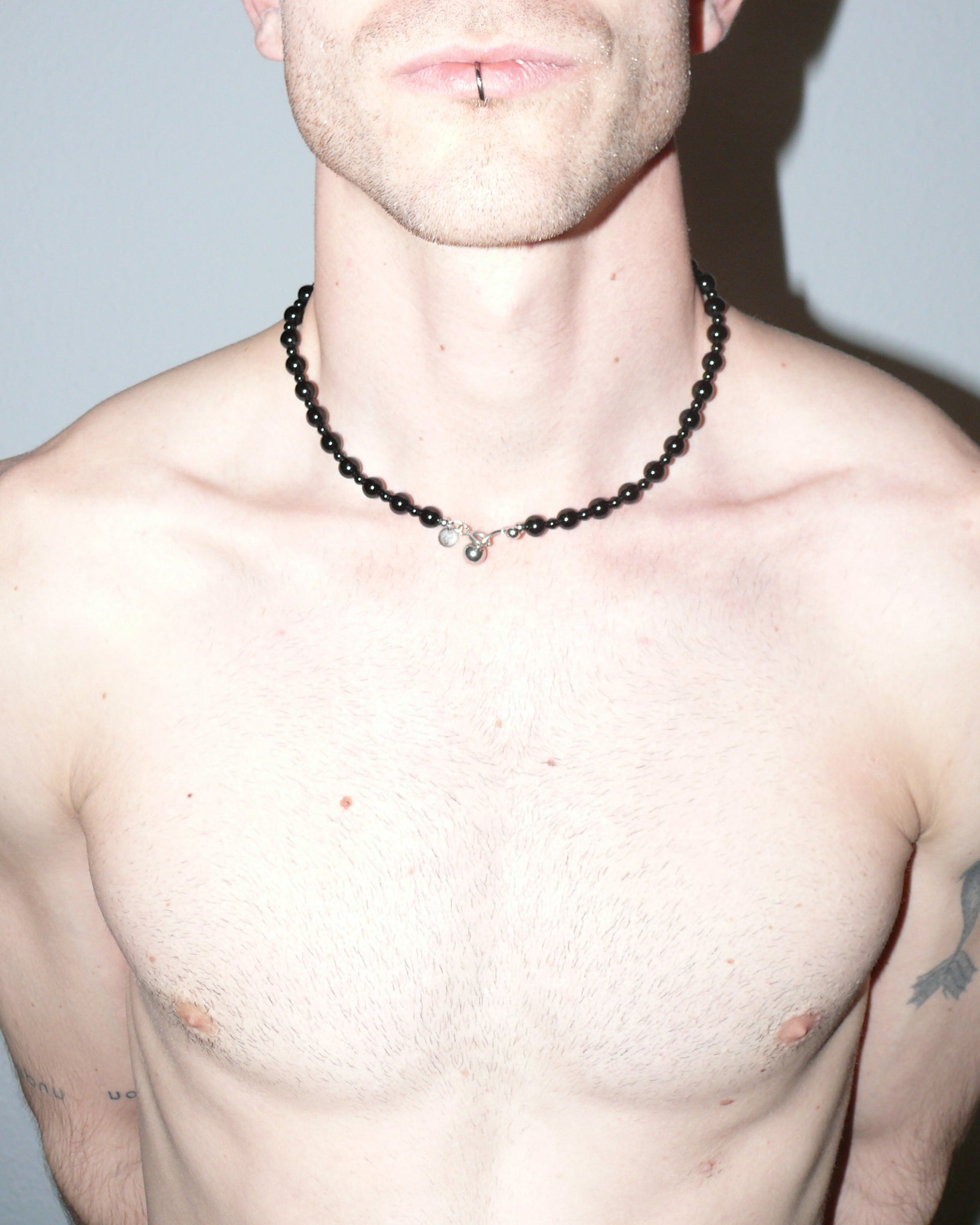 Black agate beads necklace with piercing closure close-up on model neck