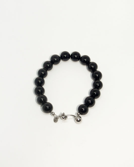Black beaded bracelet with a silver clasp on a white background