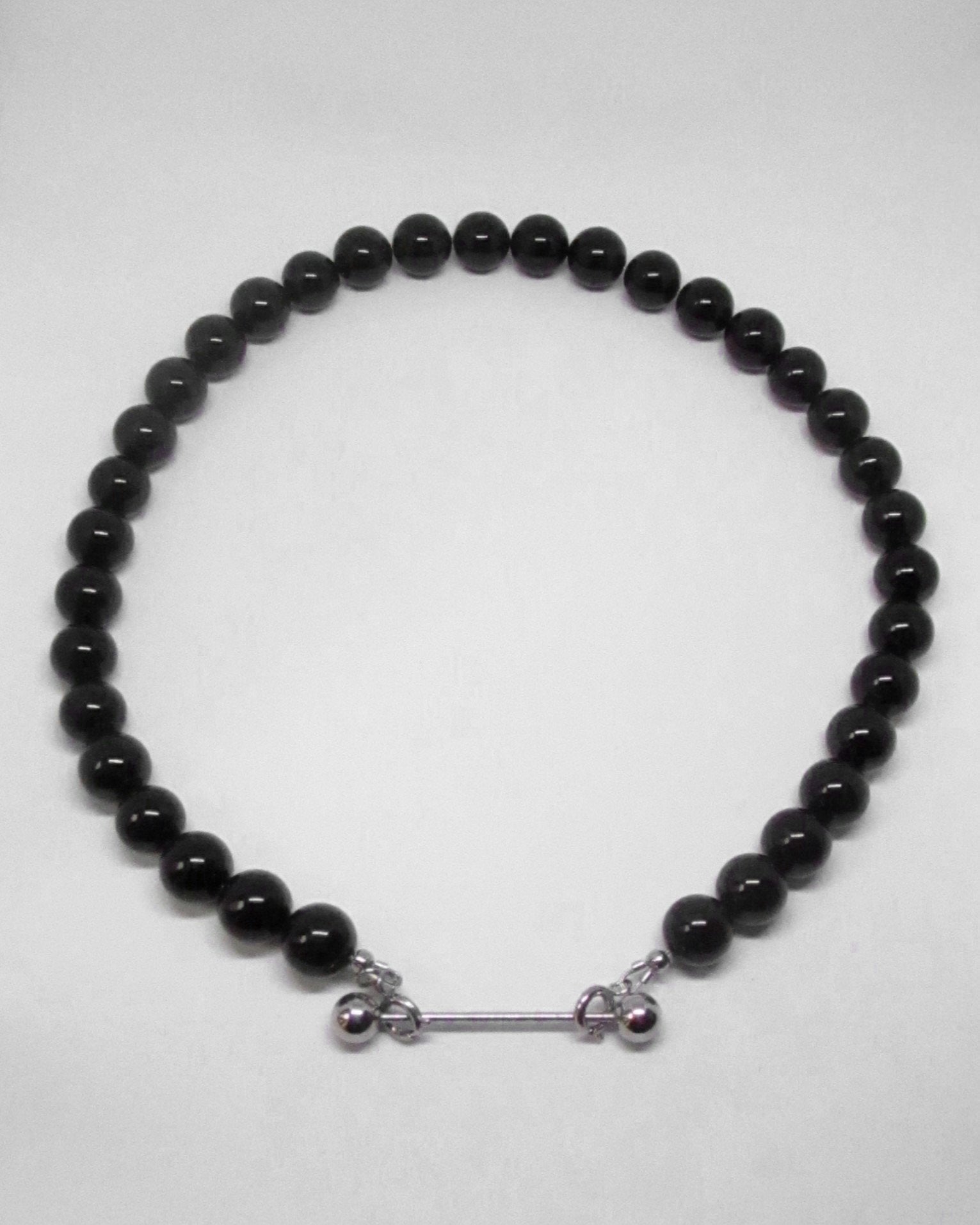Black beaded necklace with silver clasp on a white background