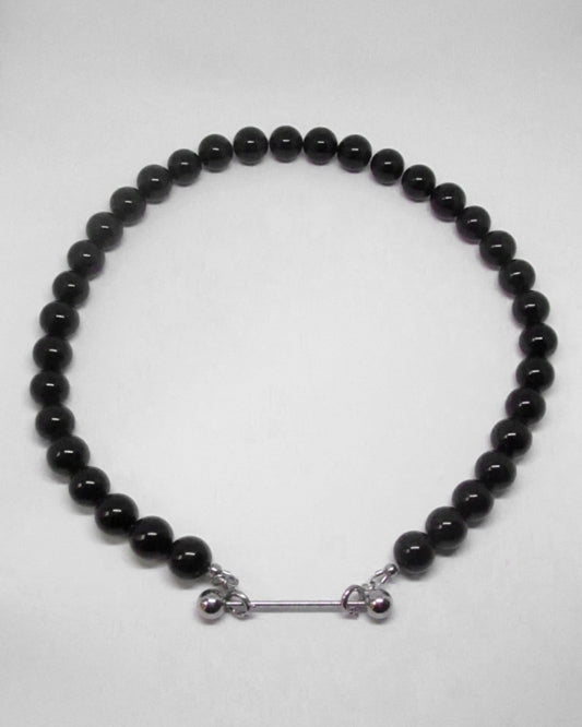 Black beaded necklace with silver clasp on a white background