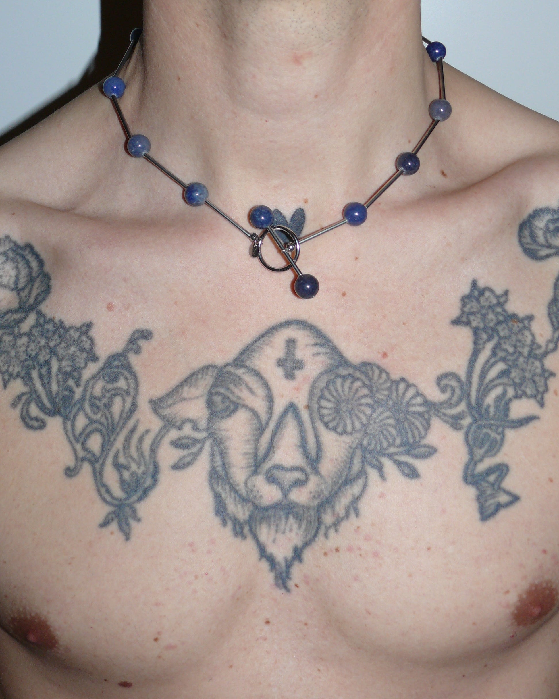 Blue beaded necklace representing water signs close up on model