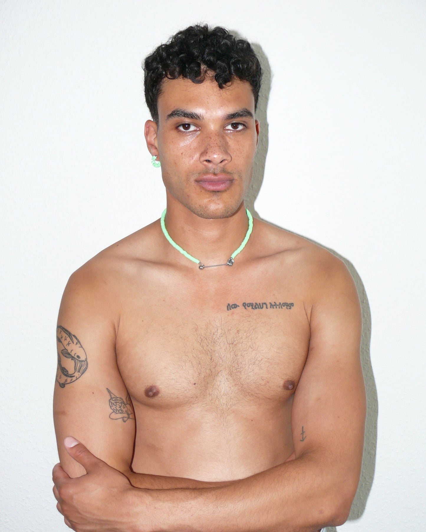 Brat green resin chips necklace with steel barbell closure portrait on model with crossed arms