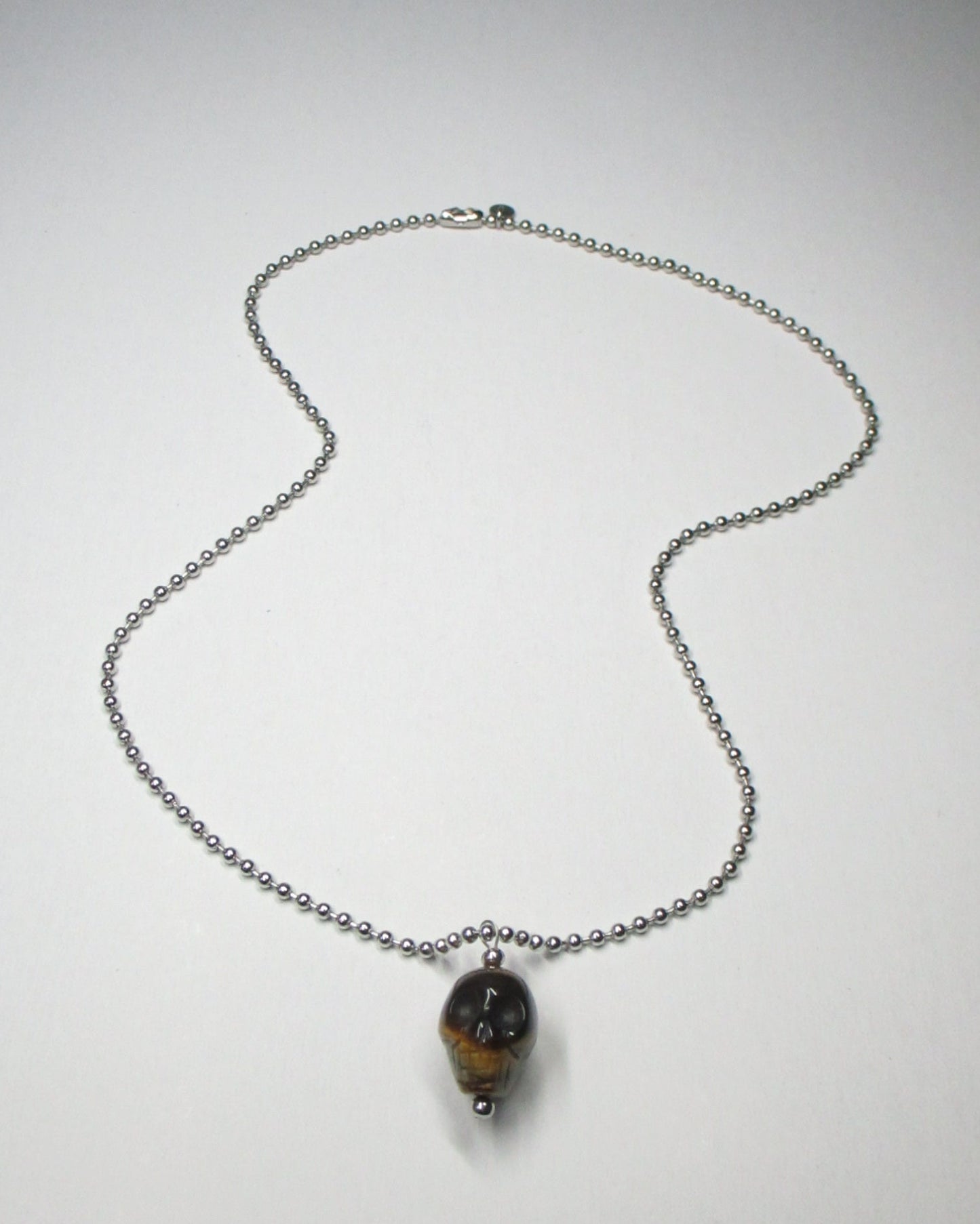 Brown tiger eye agate skull pendant necklace fluid still portrait