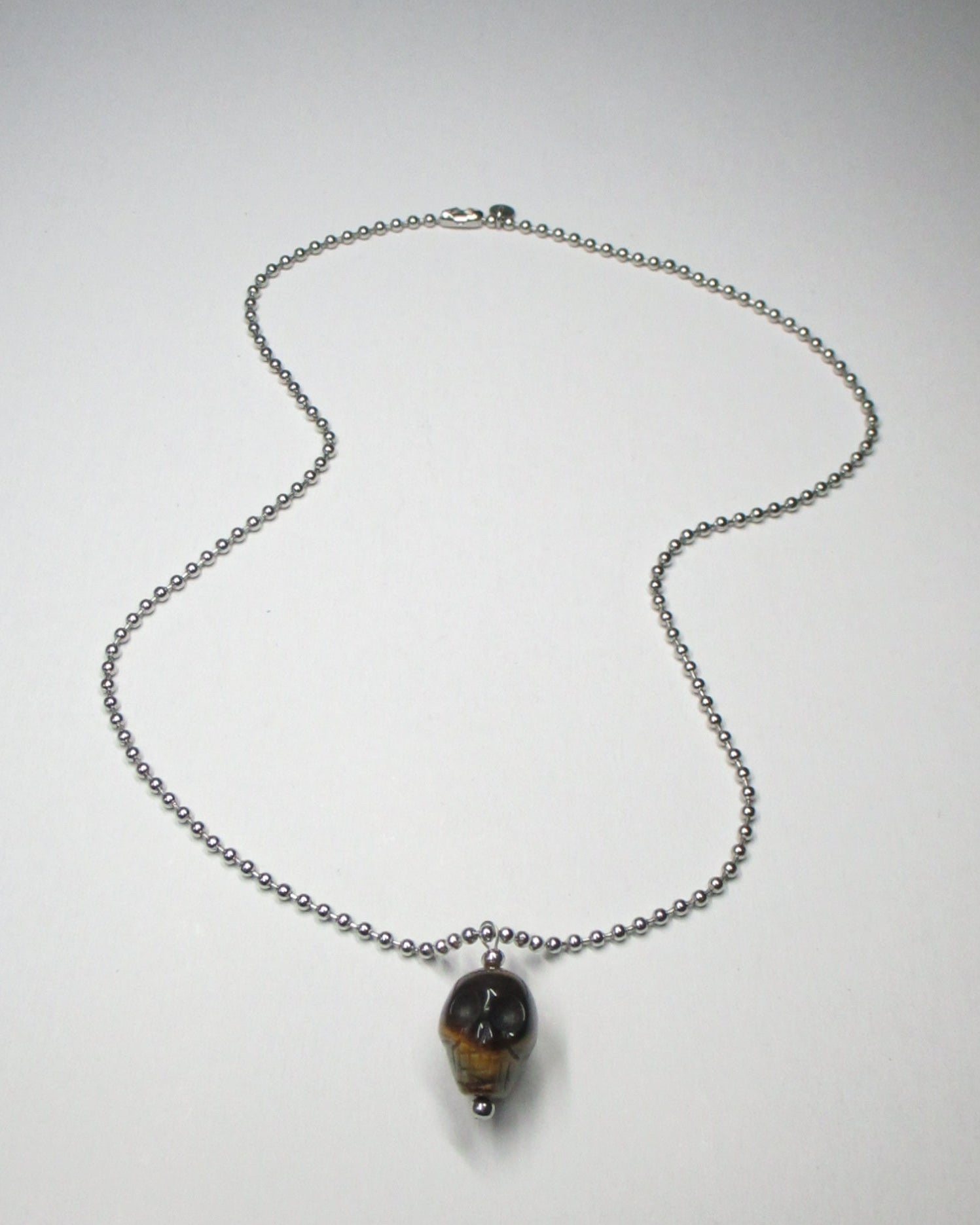 Brown tiger eye agate skull pendant necklace fluid still portrait