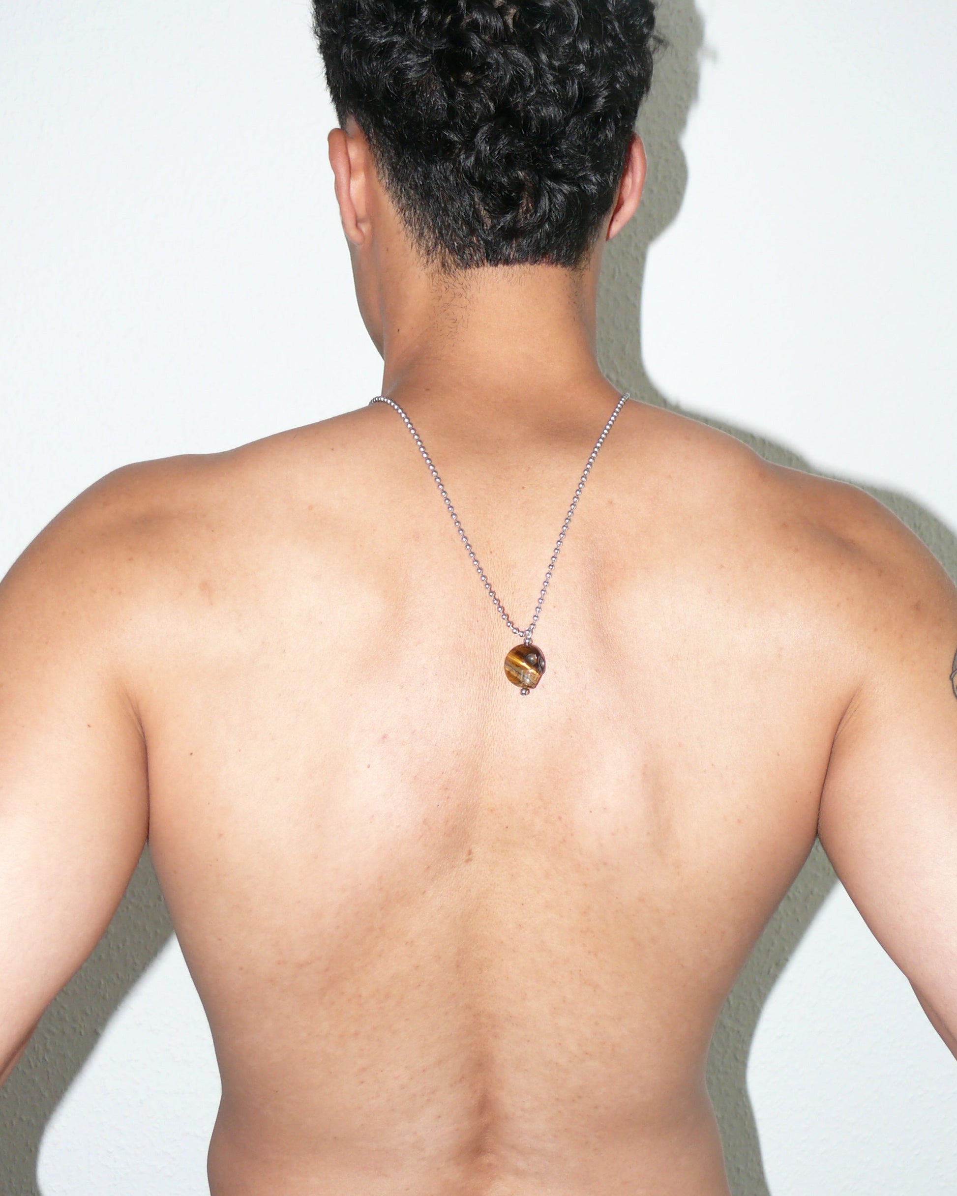 Brown tiger eye agate skull pendant necklace portrait on model back