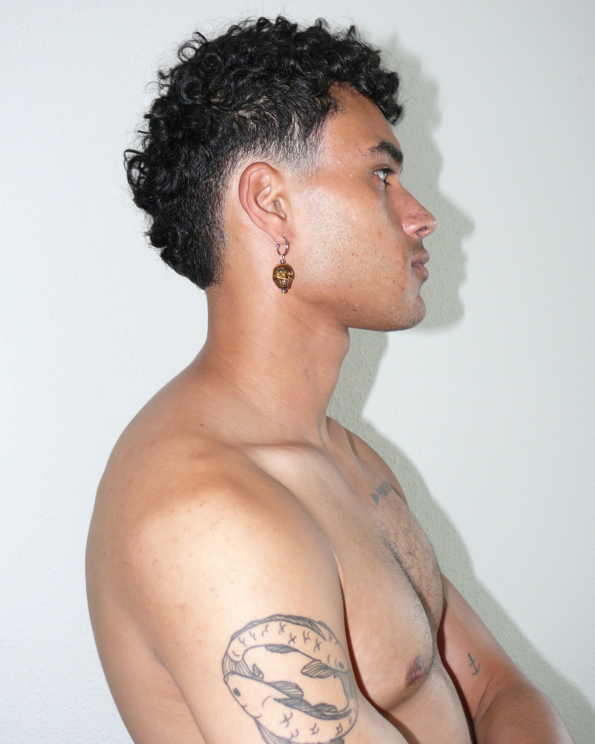 Brown tiger eye agate skull pendant single earring portrait on model