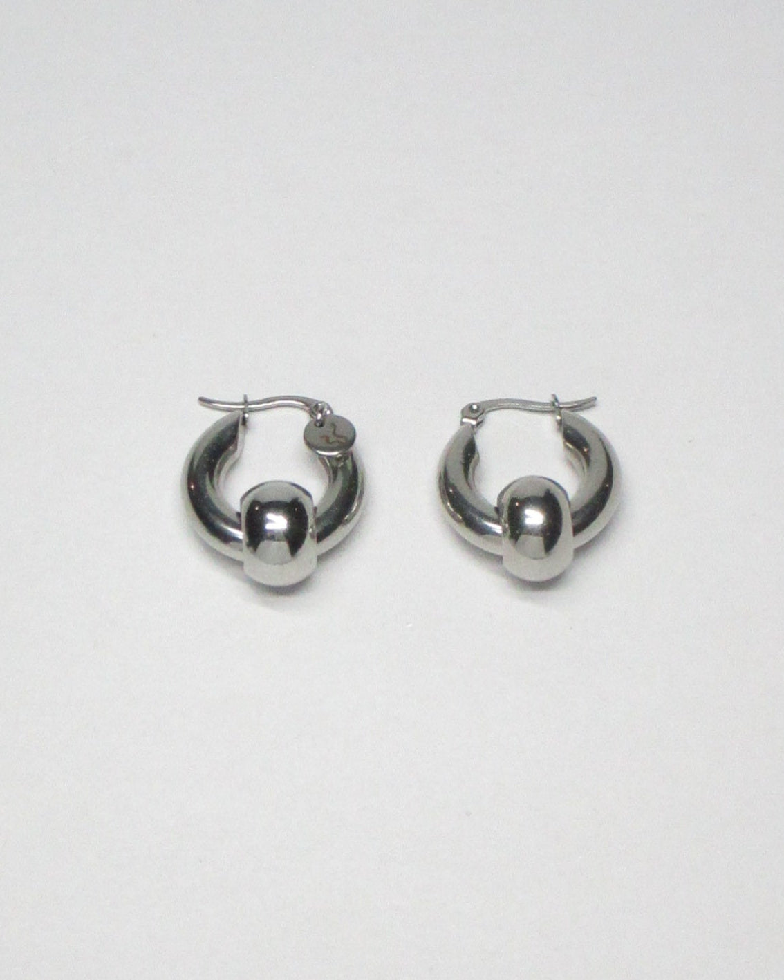 Captive style piercing steel hoops earrings still portrait