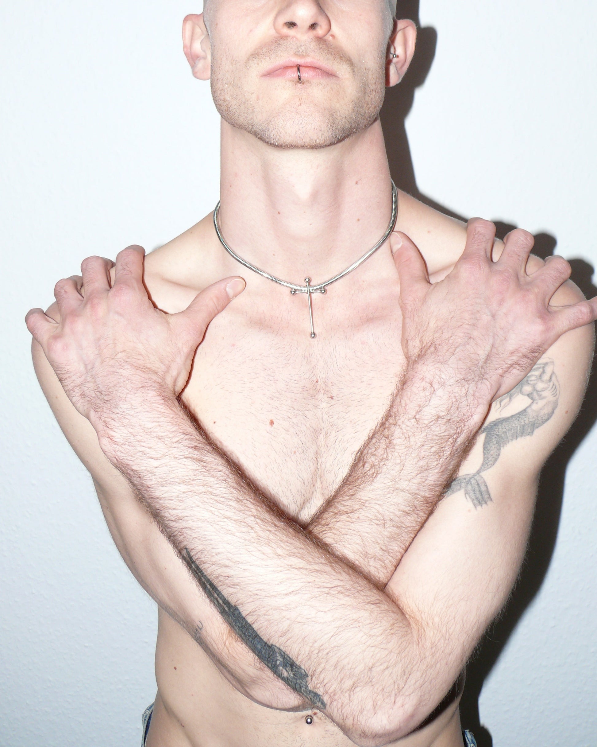 Cross shaped barbells pendant snake steel necklace portrait on model with crossed arms