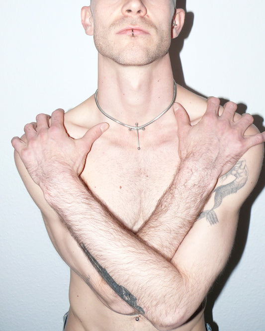 Cross shaped barbells pendant snake steel necklace portrait on model with crossed arms