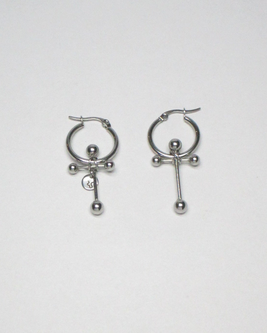 Cross shaped steel barbell hoop earrings still portrait
