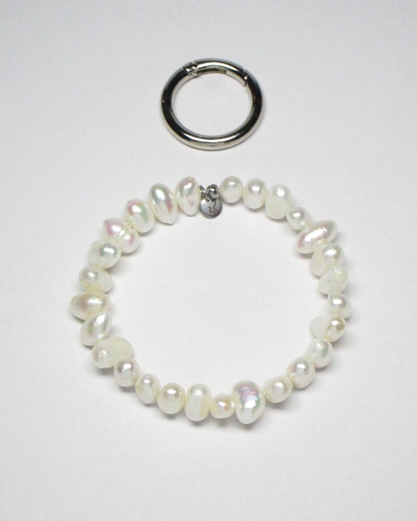 Freshwater pearls key and cock ring with dtatched carabiner still portrait