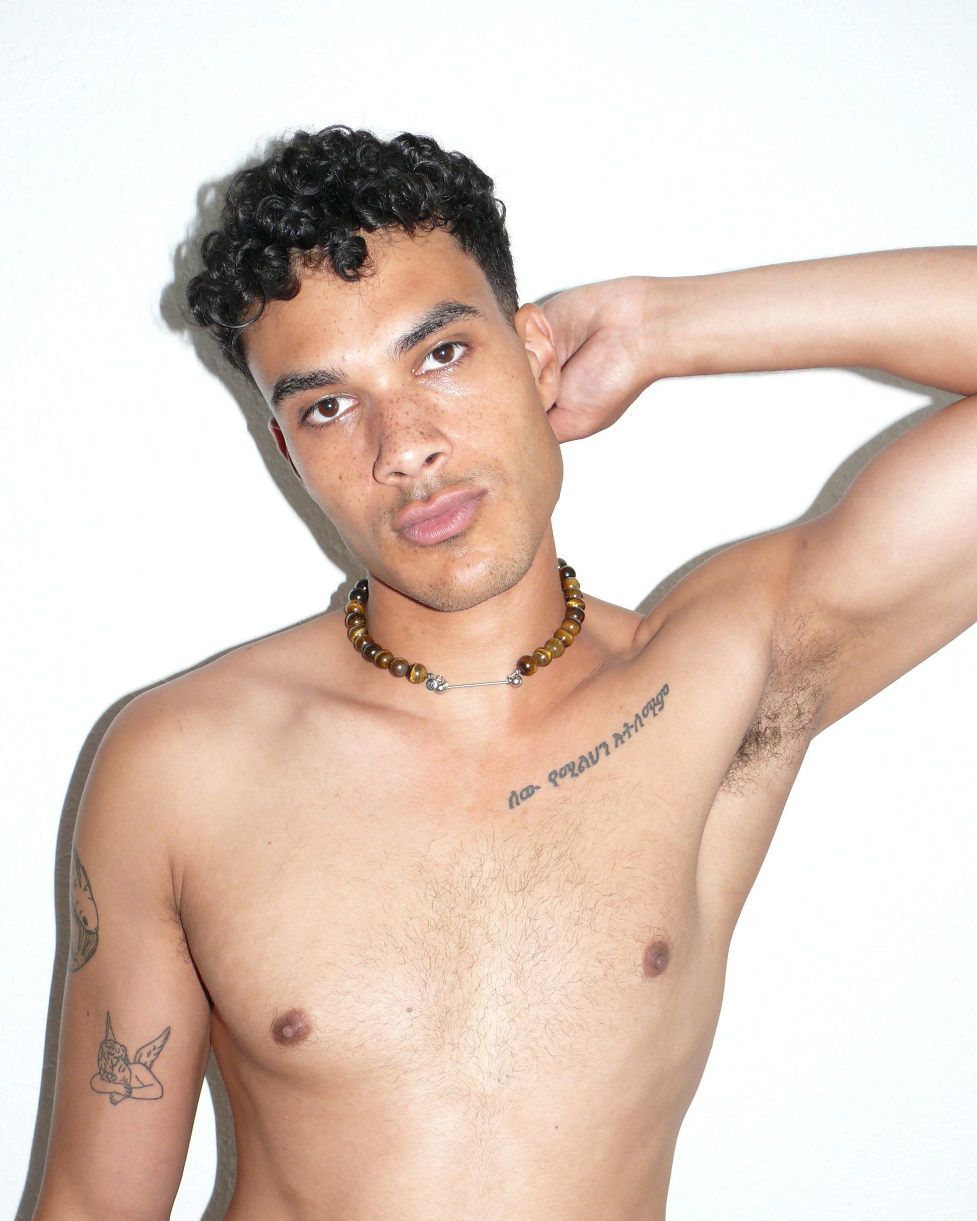 Gemstone tigereye agate necklace with piercing closure close up portrait on model with arm up