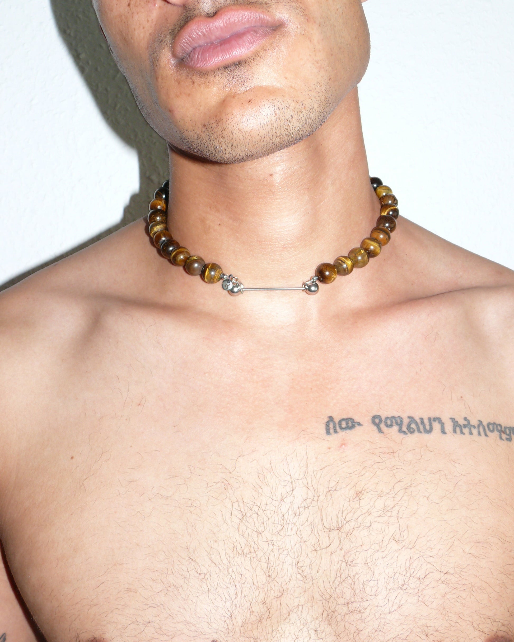 Gemstone tiger eye agate necklace with piercing closure close up portrait on model