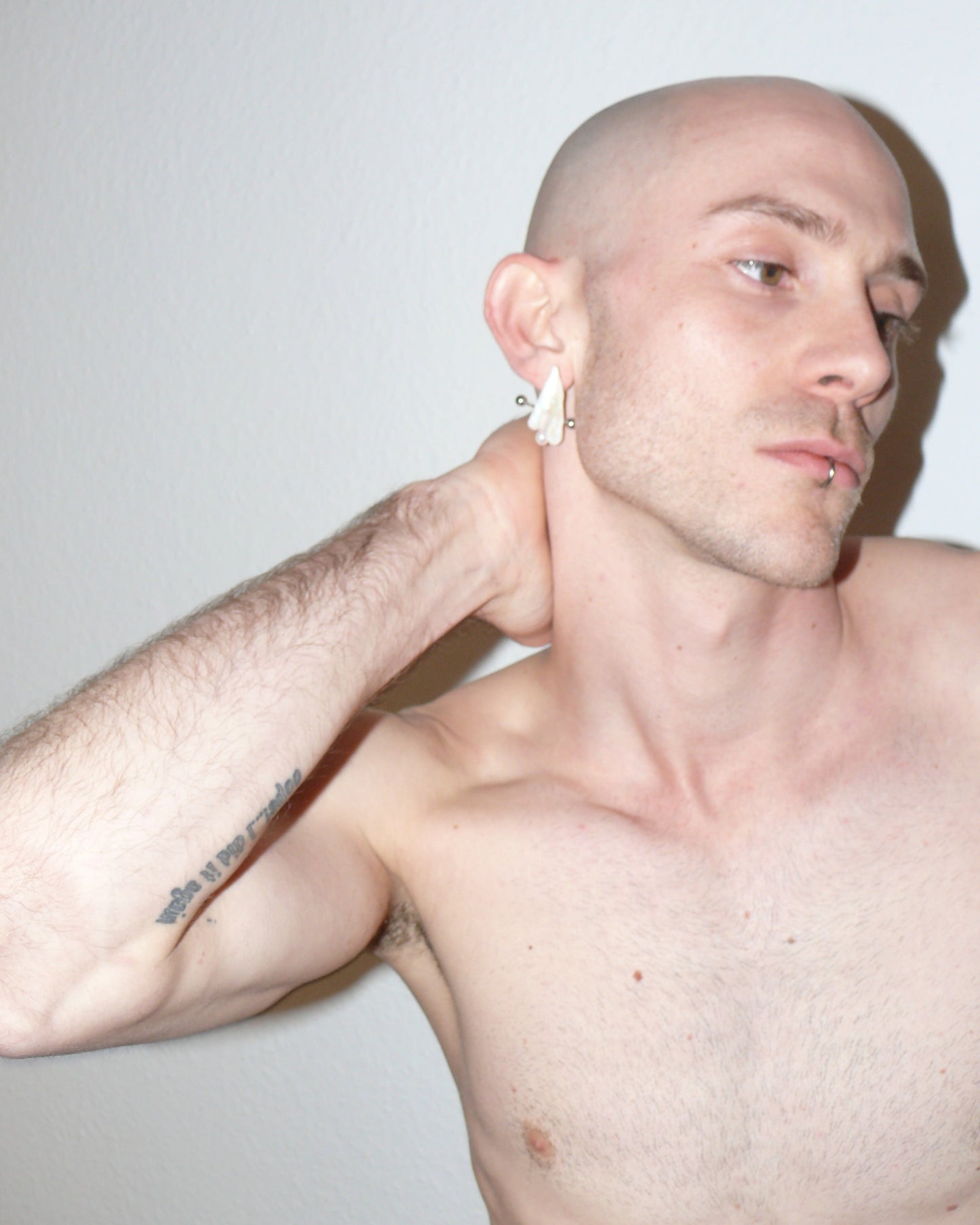 Ghost shaped freshwater pearl earrings with piercing decoration close up on model right side