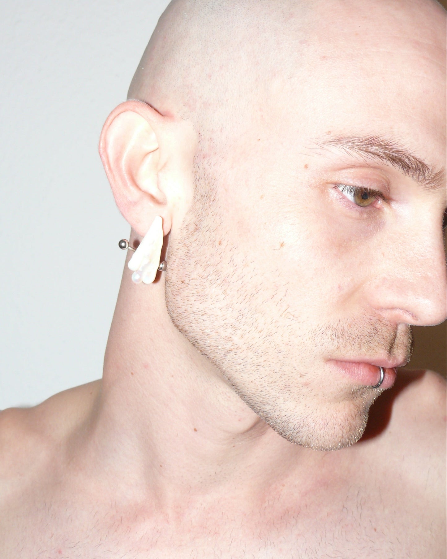 Ghost shaped freshwater pearl earrings with piercing decoration close up on model