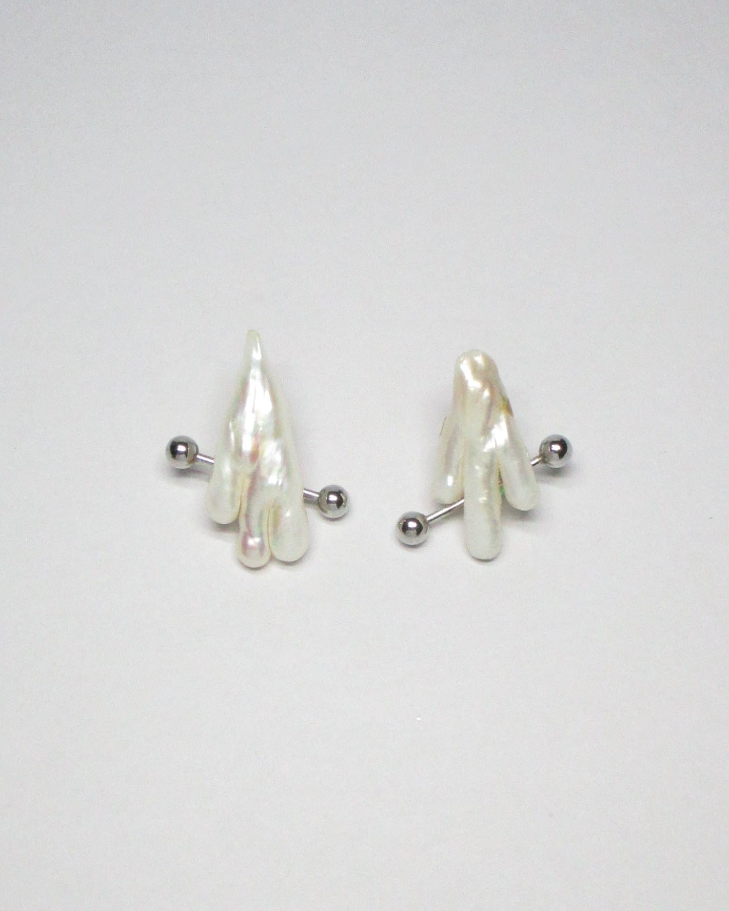 Ghost shaped freshwater pearl earrings with piercing decoration still portrait