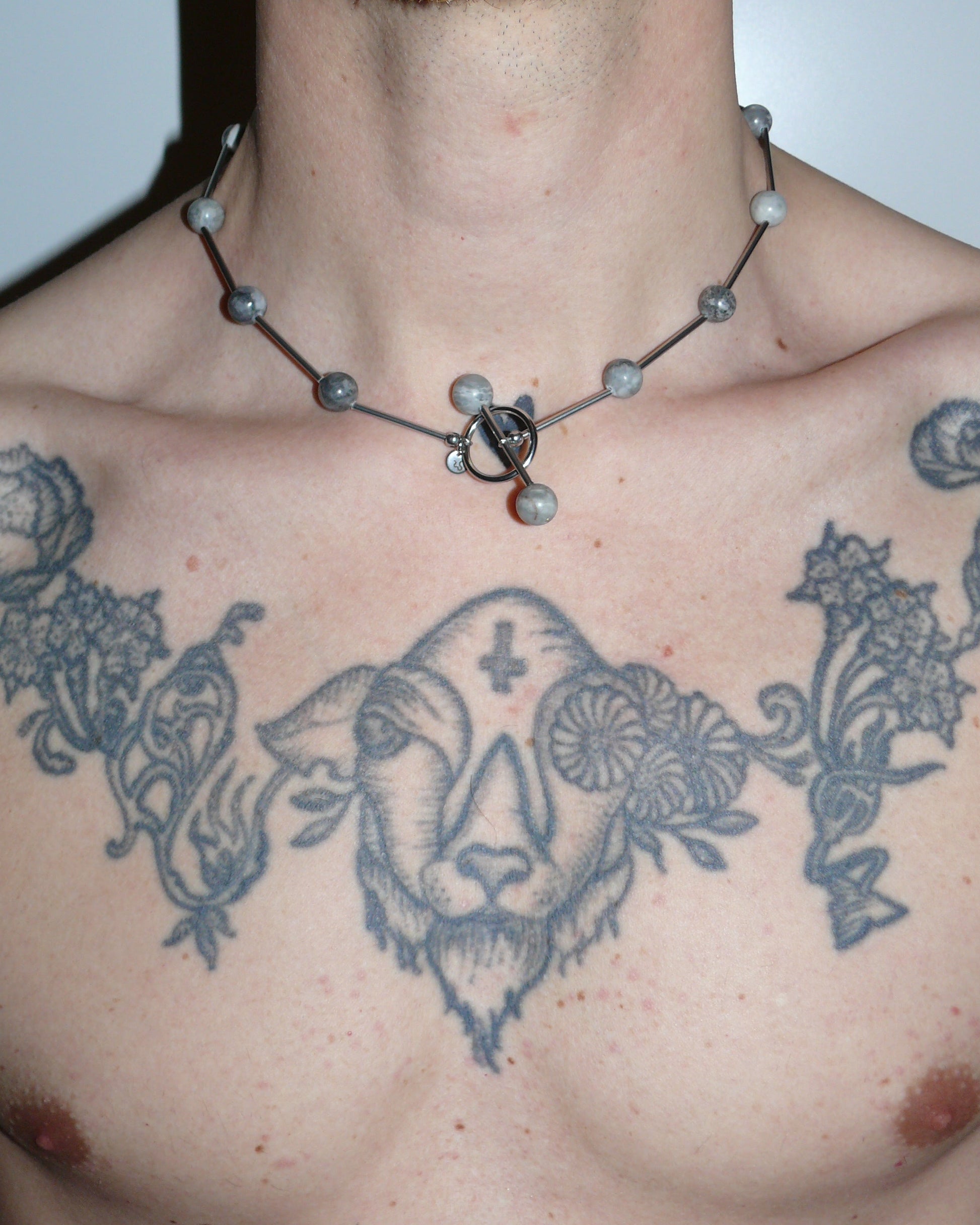 Gray beaded necklace representing air signs close up on model