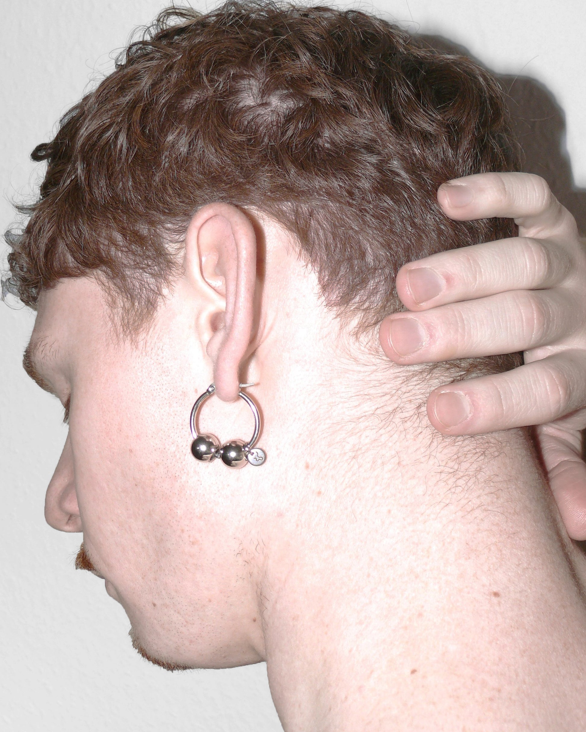 Lateral portrait of model wearing big hoop with boulles decoration