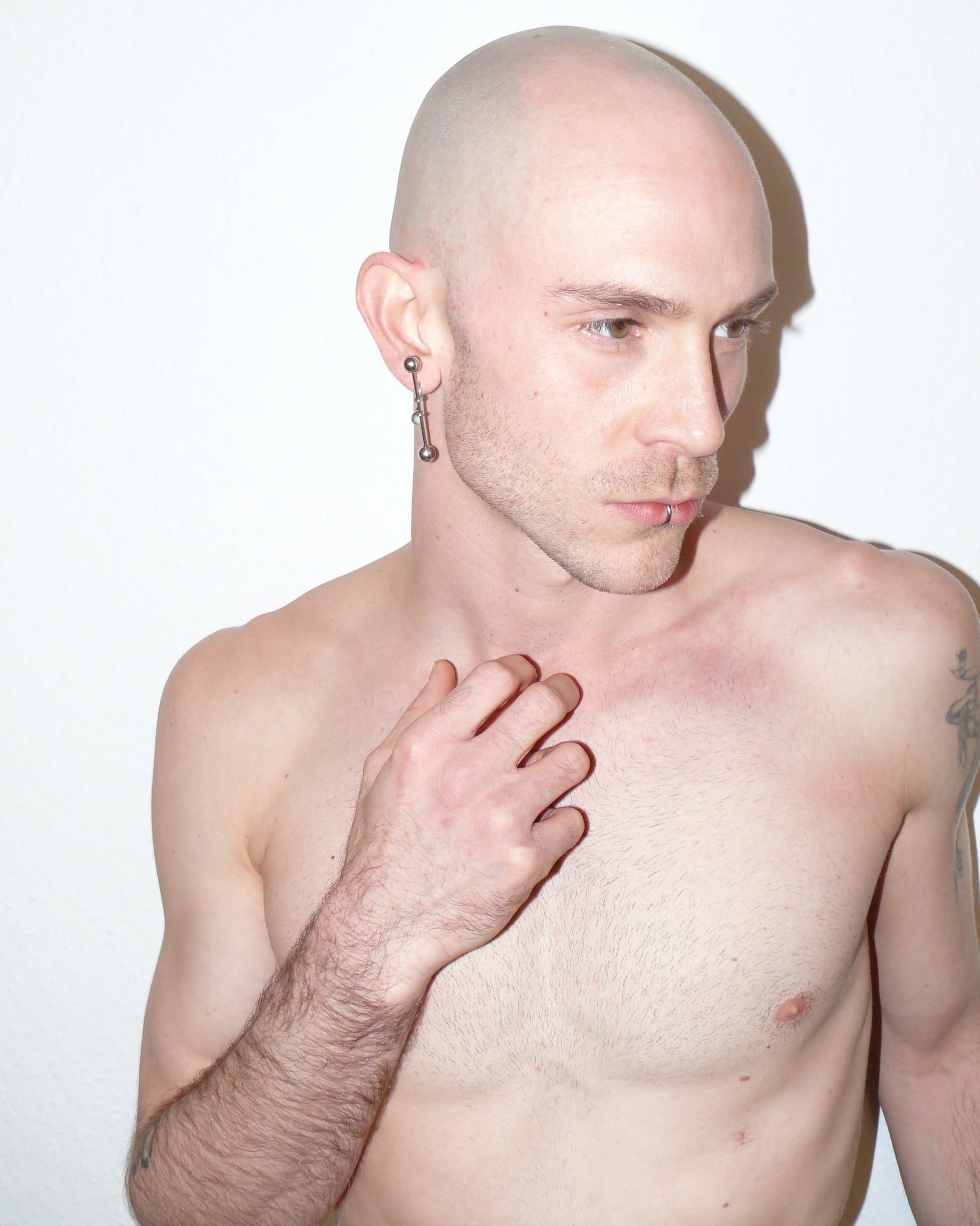 Maxi barbell piercing single earring side portrait on white model with rising hand