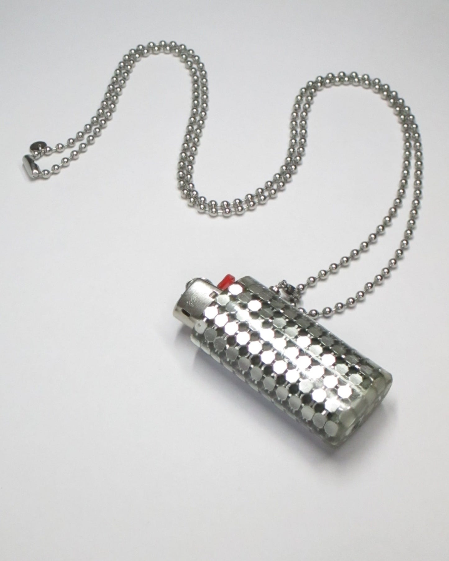 Metal mesh lighter case casted in transparent resin with chain still portrait