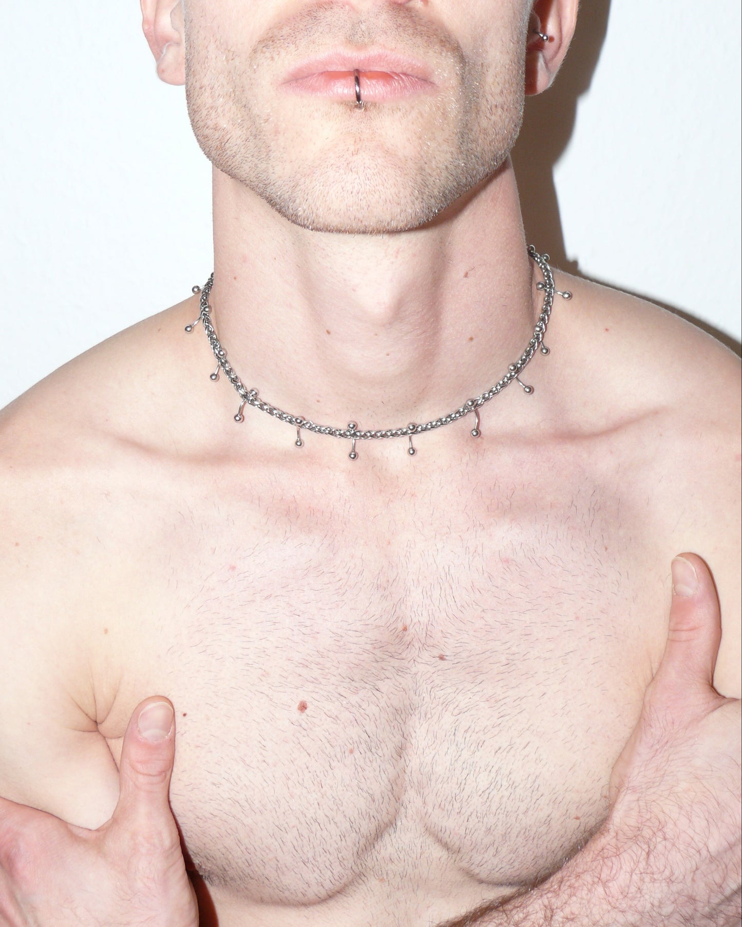 Mille barbell piercing necklace close- up portrait on model with crossed arms