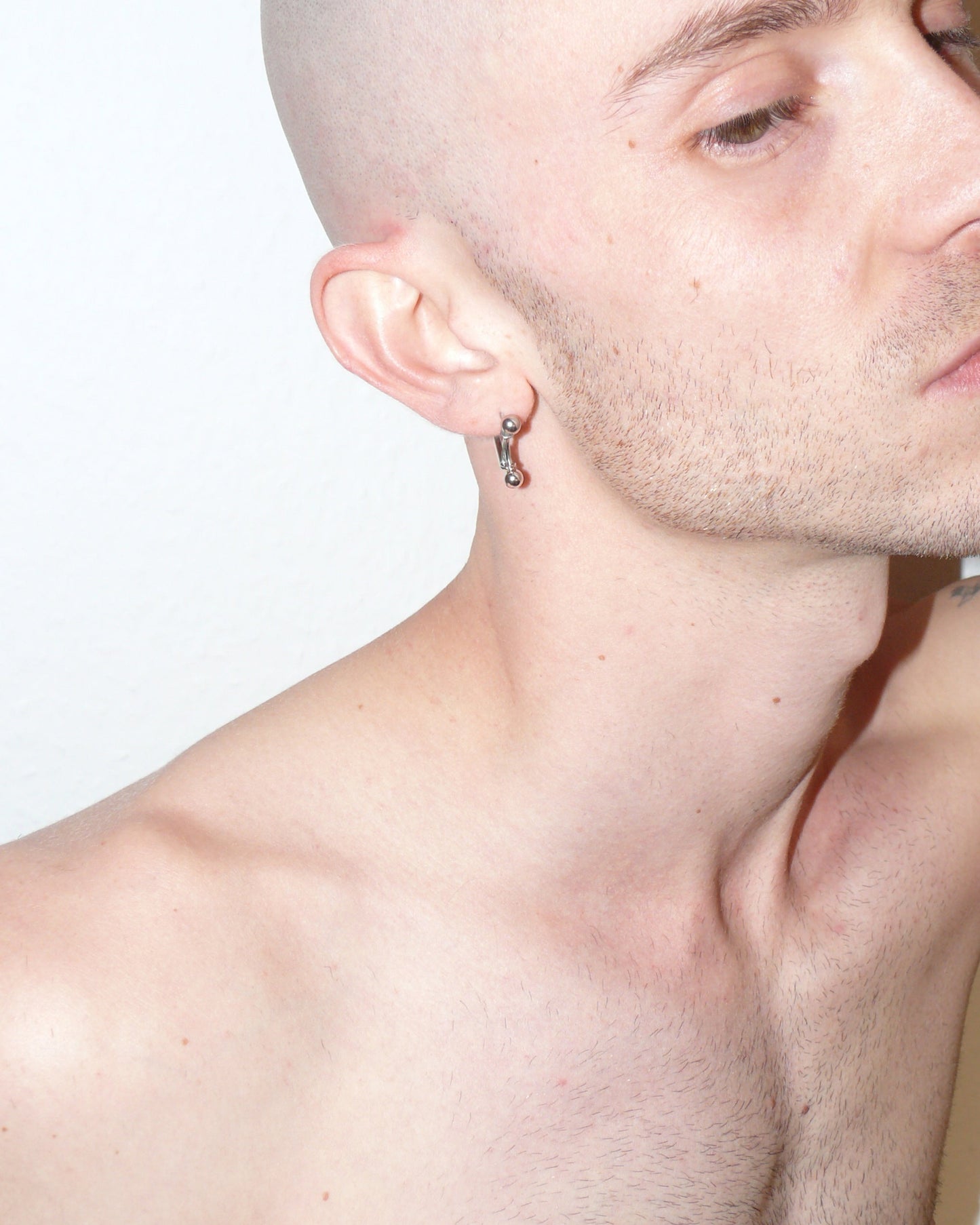 Mini banana piercing earrings close-up on white model