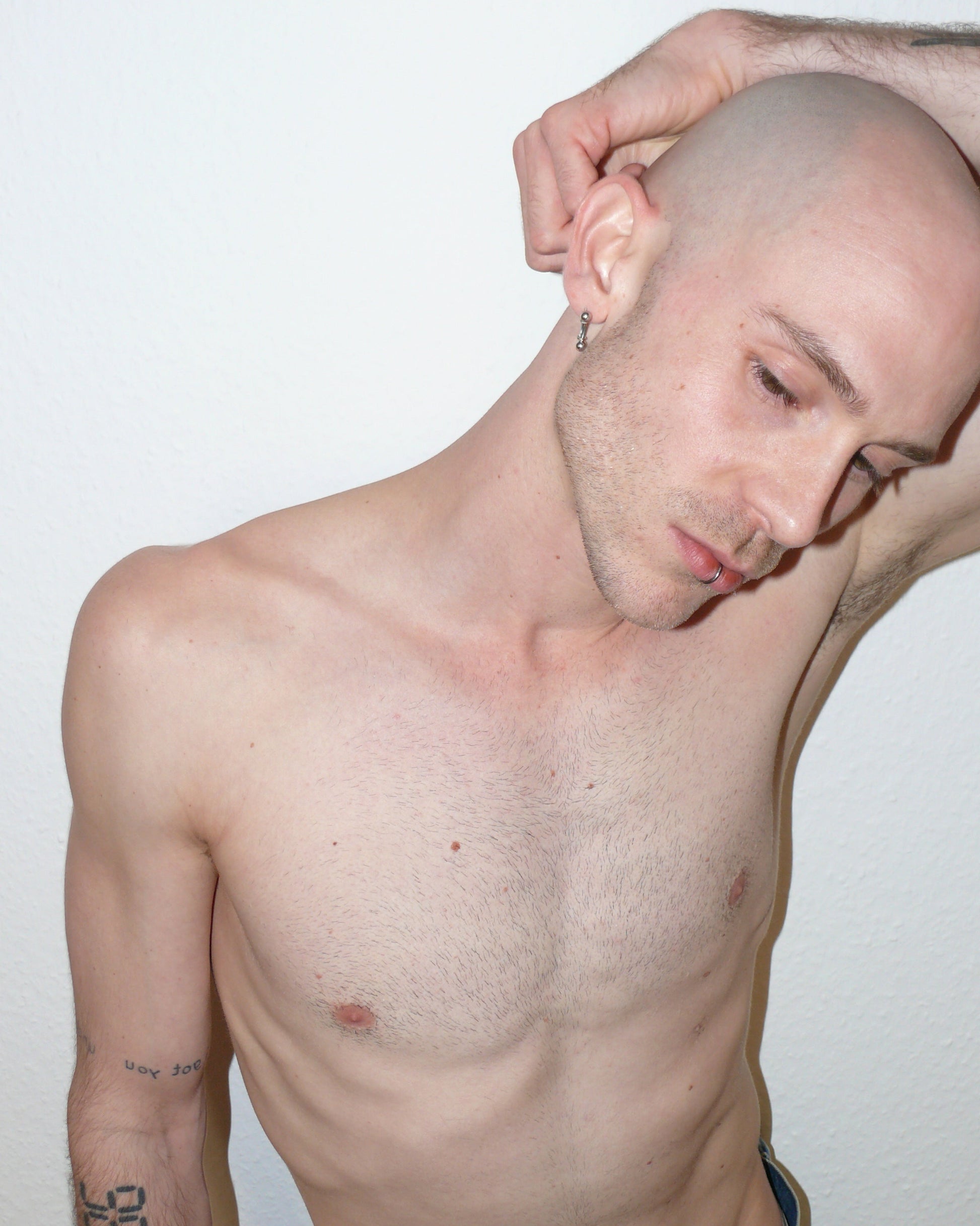 Mini banana piercing earrings side portrait on white model with rising arm