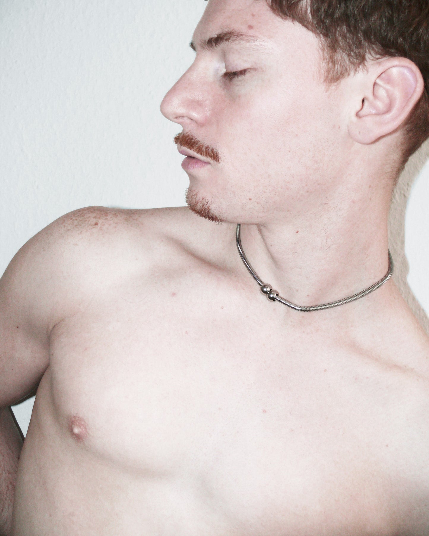 Model lateral portrait wearing snake necklace with two boulles decoration