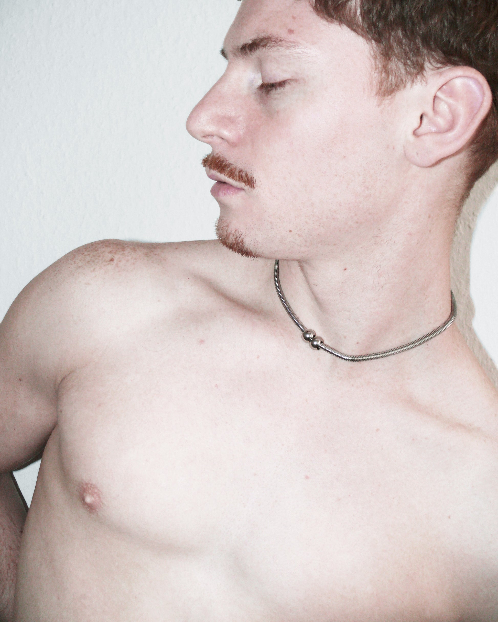 Model lateral portrait wearing snake necklace with two boulles decoration