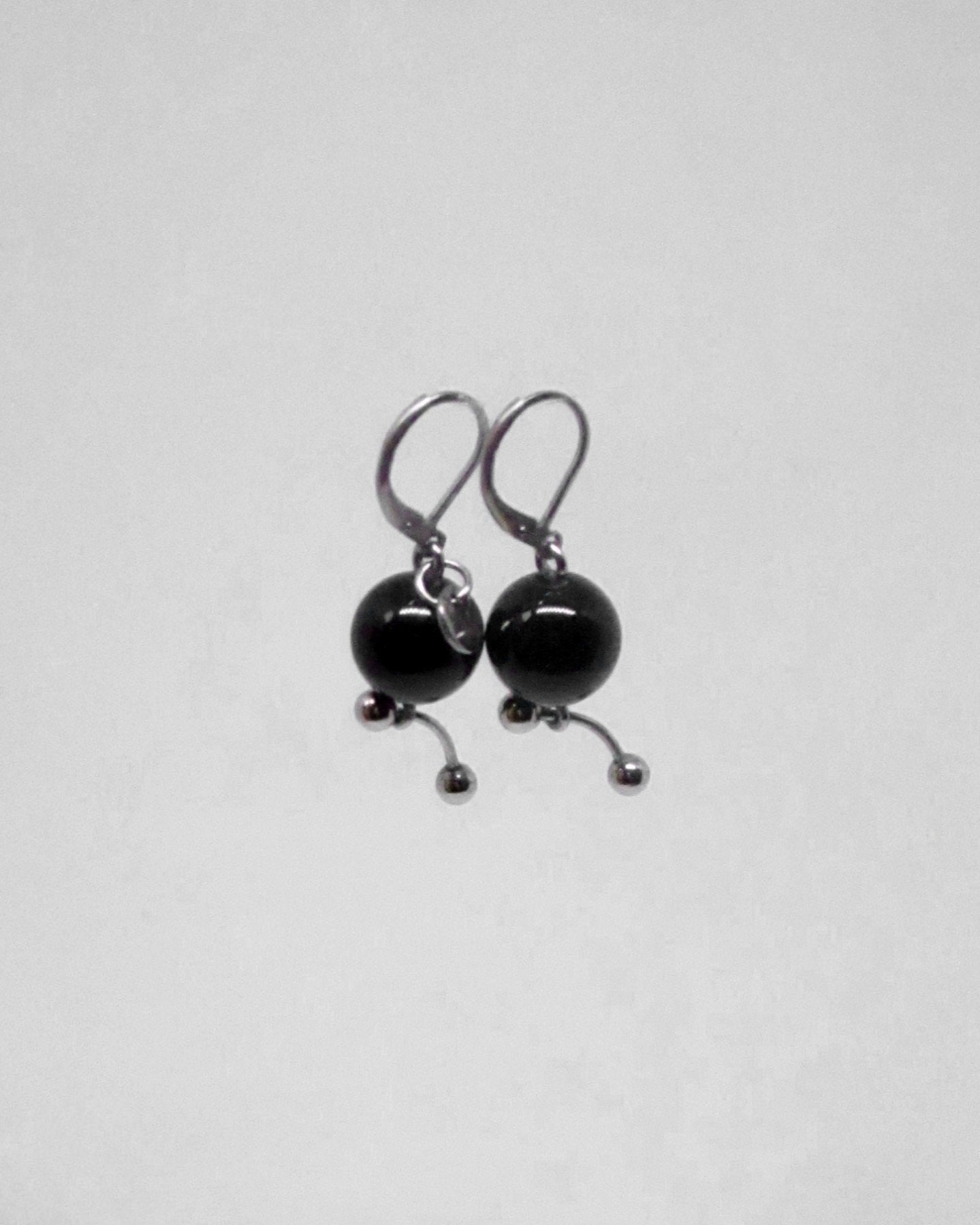 Pair of black bead earrings on a light gray background