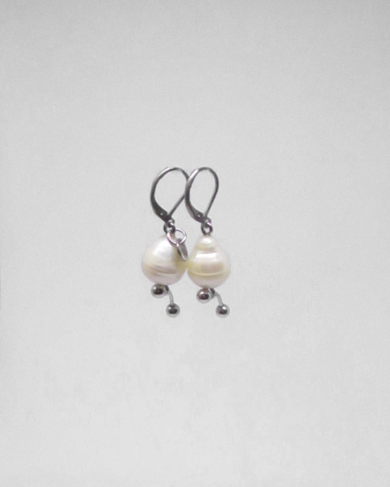 Pair of pearl earrings on a light gray background
