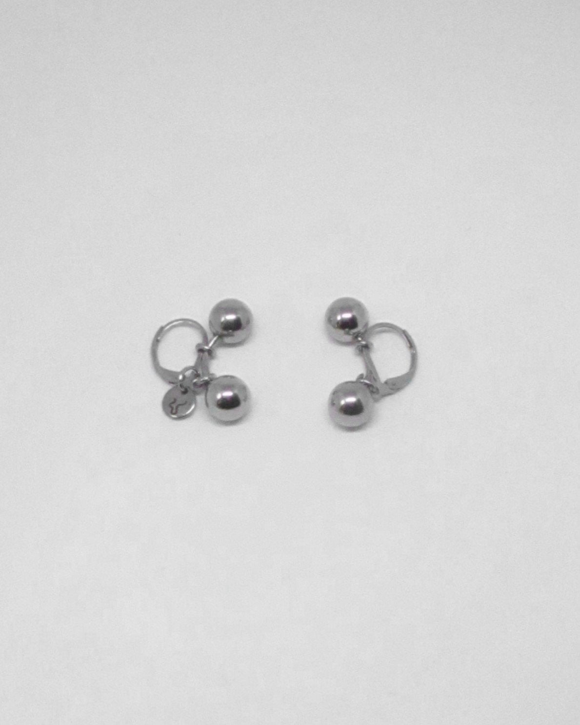 Pair of silver earrings on a light gray background