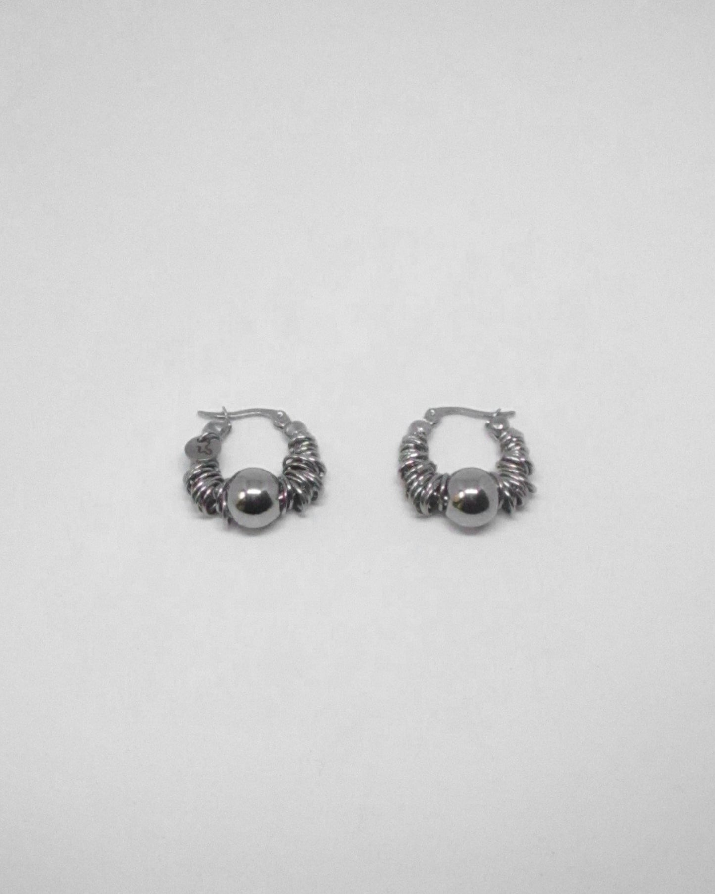 Pair of silver hoop earrings on a light gray background