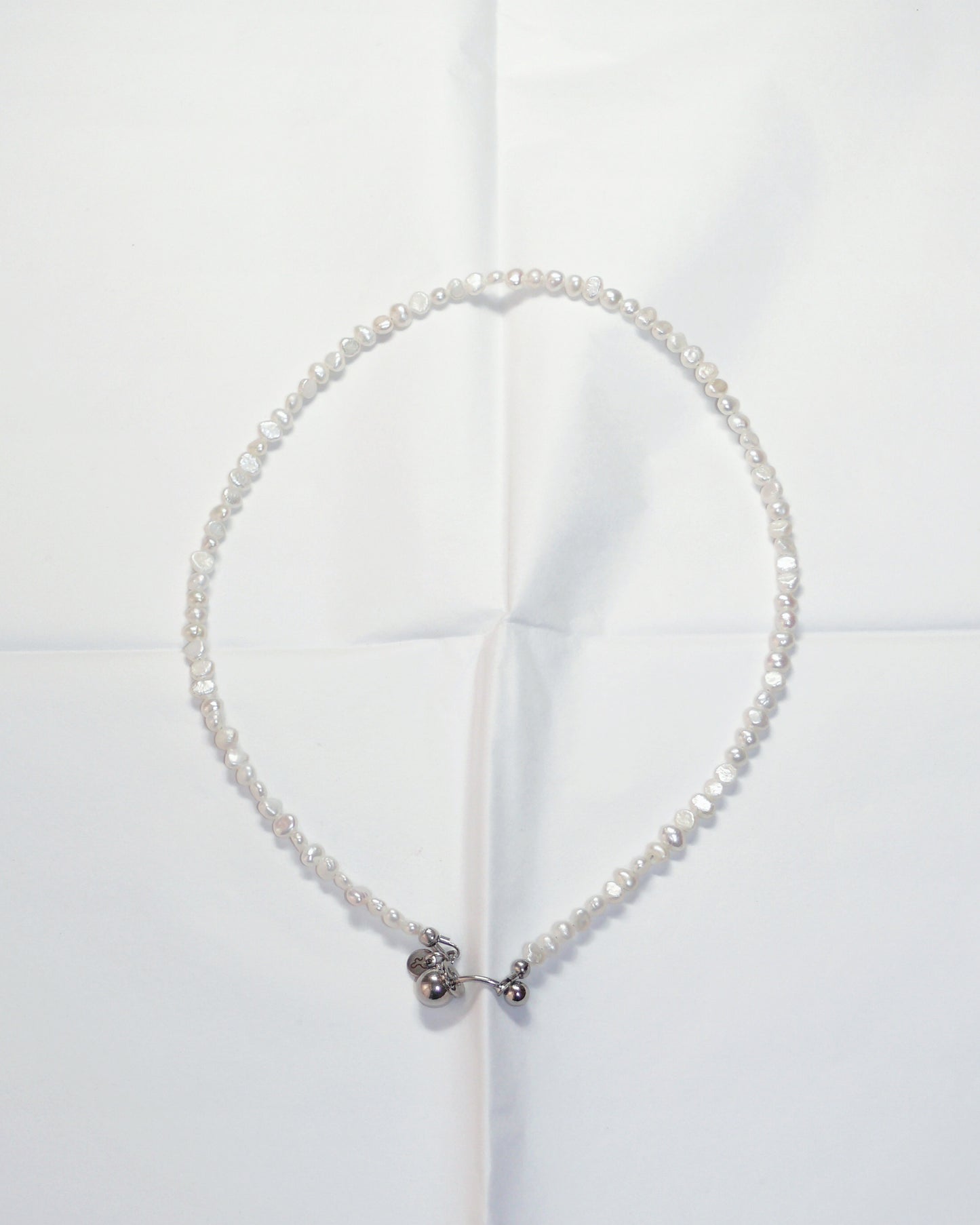 Pearl necklace with a silver clasp on a white background