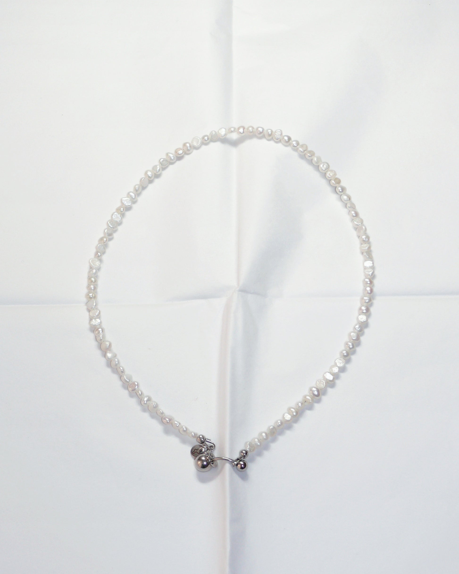 Pearl necklace with a silver clasp on a white background