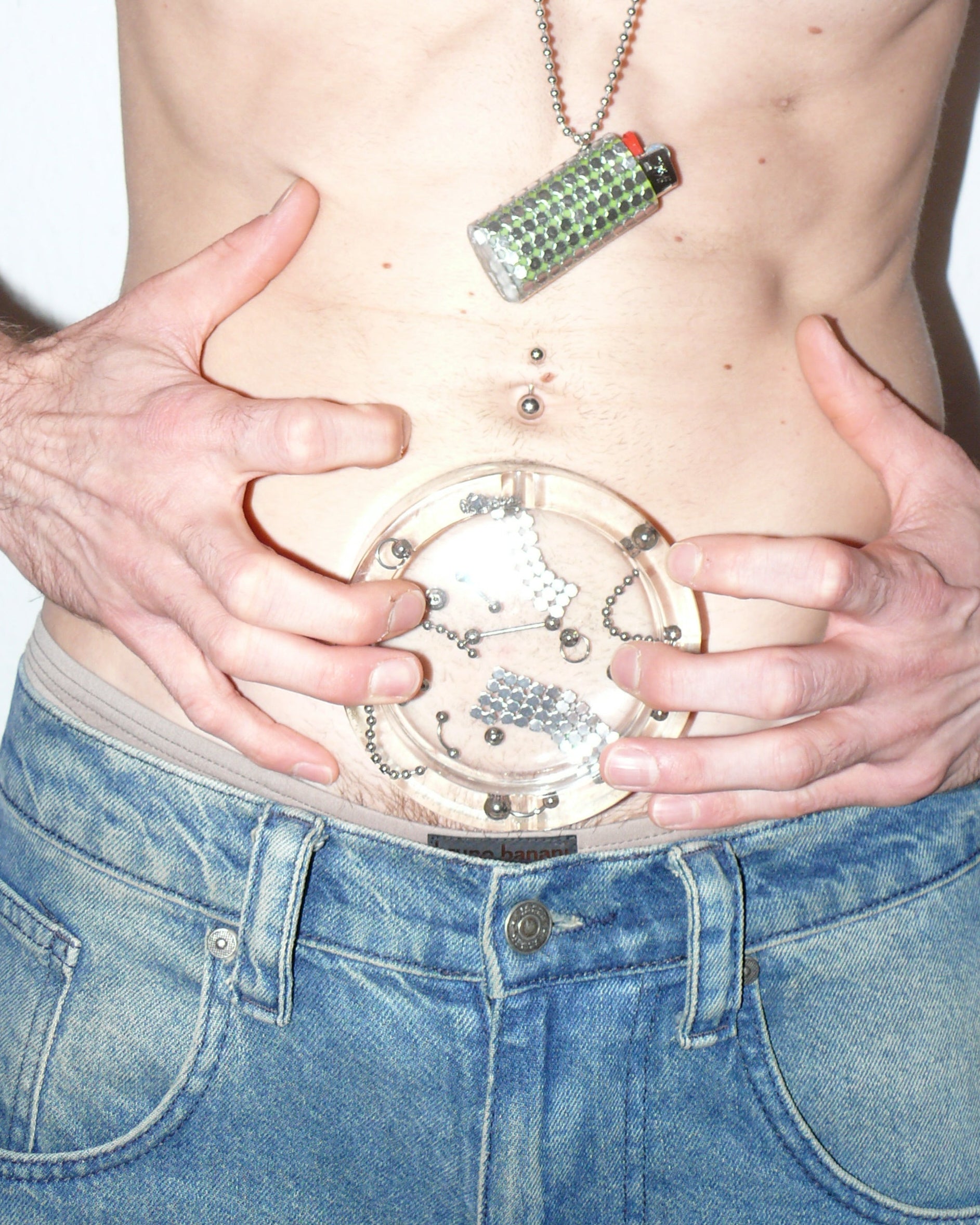 Person wearing a resin hashtray on their abdomen and chest against a white background