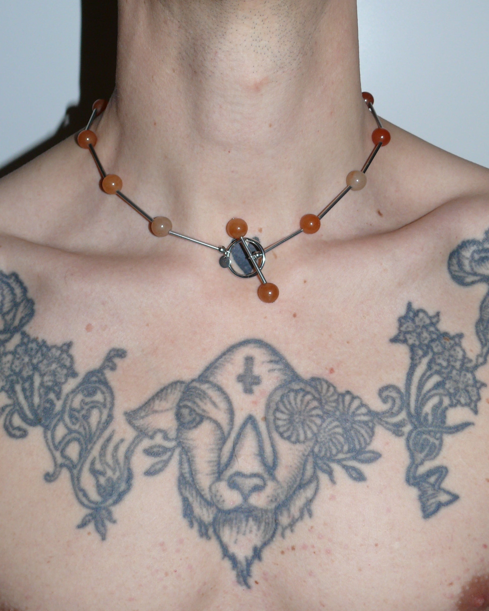 Red beaded necklace representing fire signs close up on model