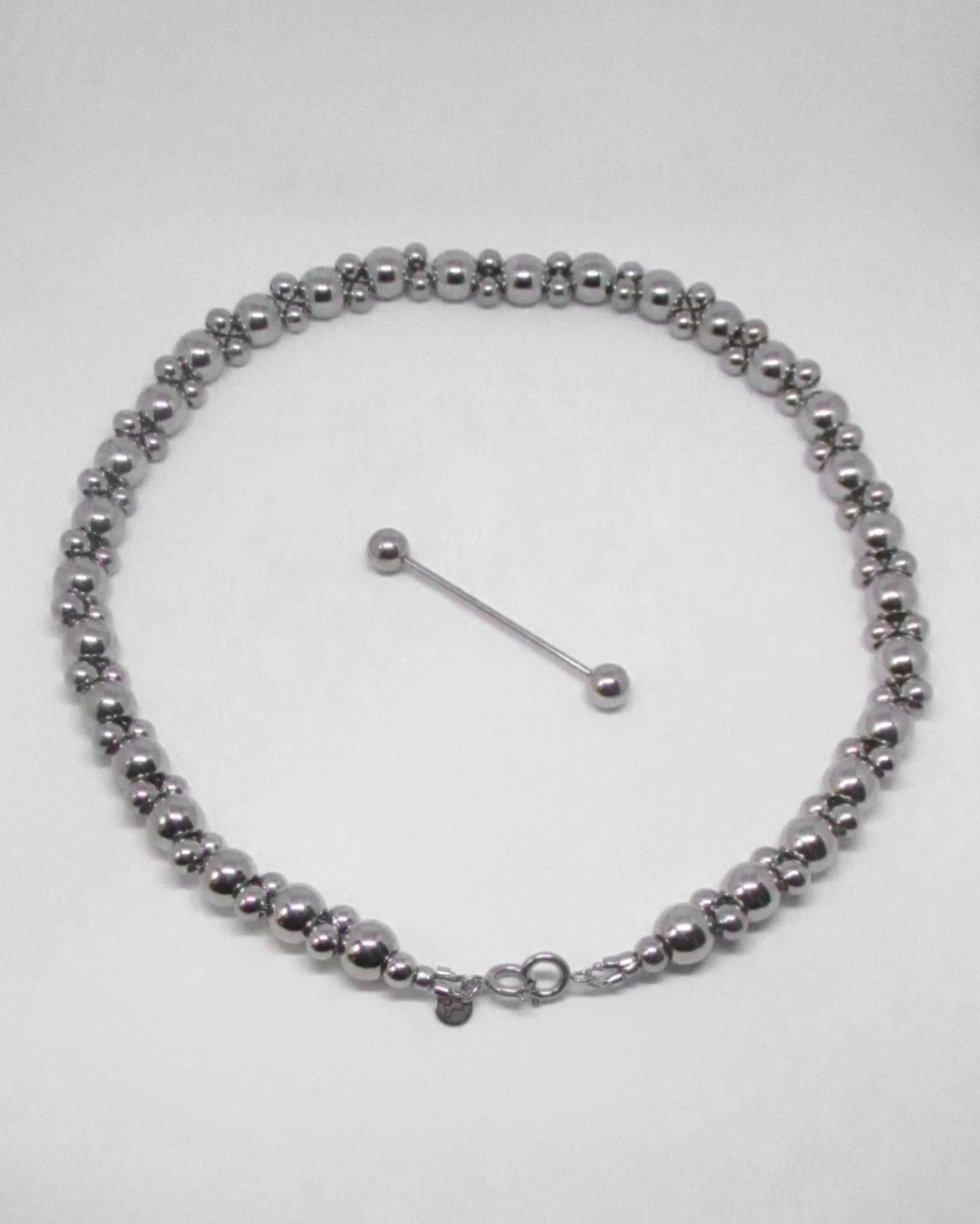 Silver doable beaded necklace with detatched piercing clousre on a white background