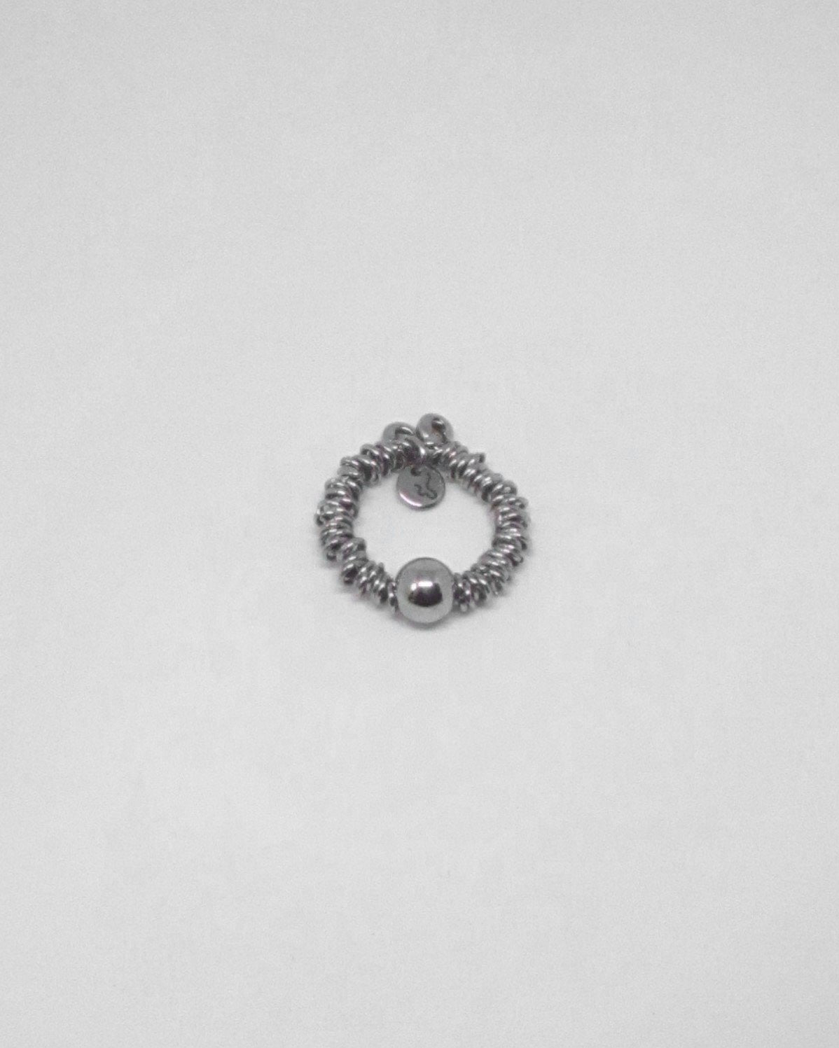 Silver ringed ring on a light gray background