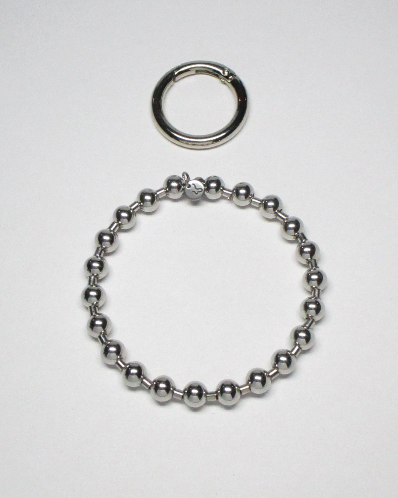 Steel ball chain key and cock ring with detatched carabiner still portrait