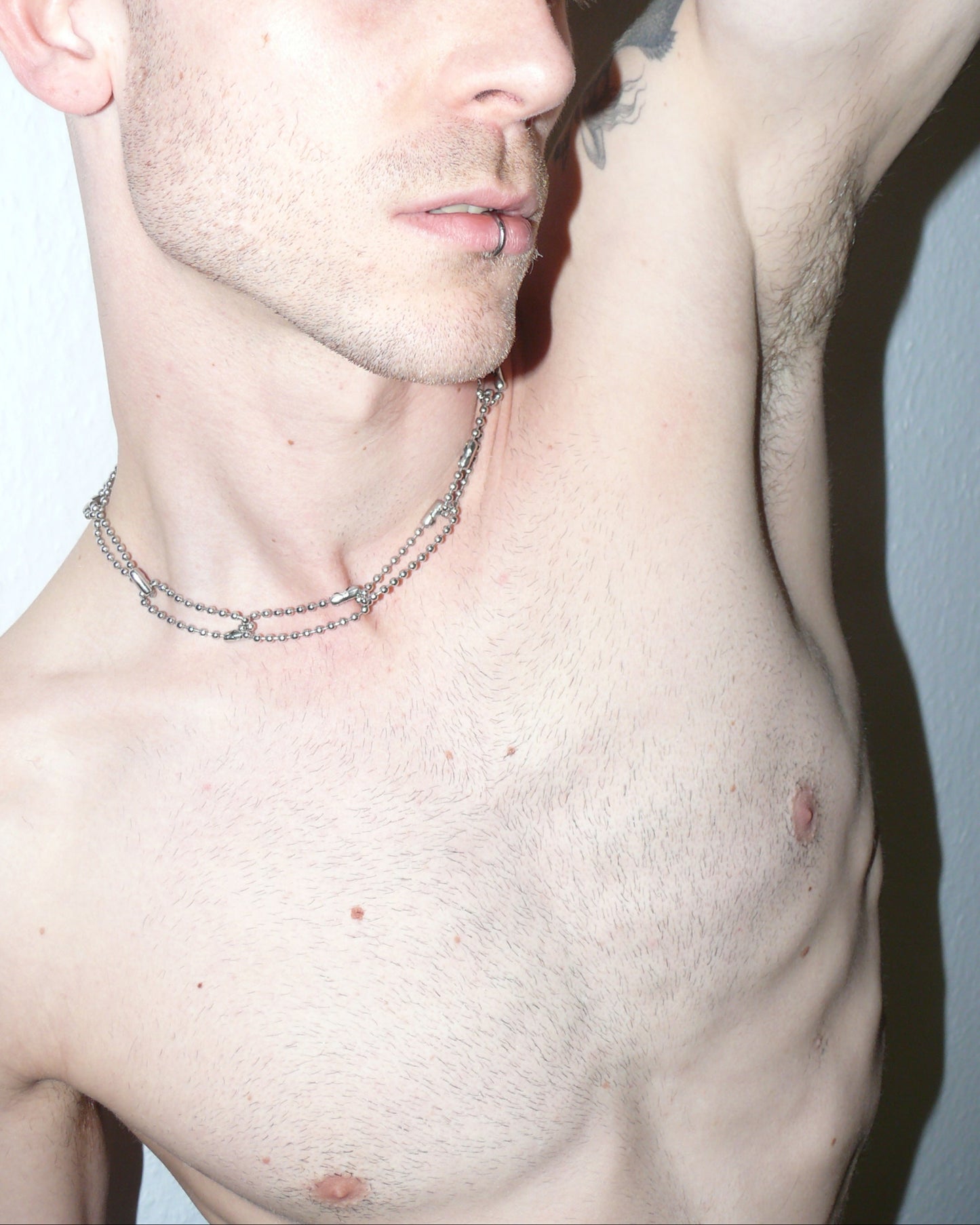 Steel ball chain multiple rings necklace close up portrait on model oblique laying